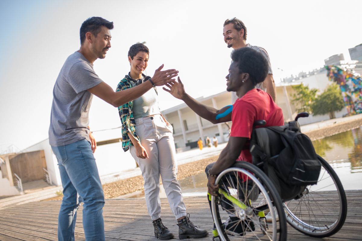 A support worker and participant sharing a high-five outdoors