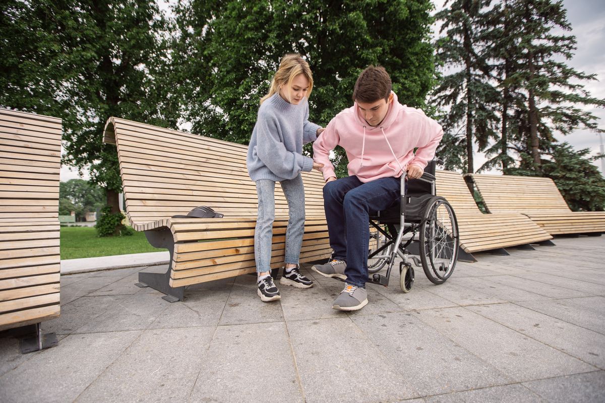 A participant using a wheelchair enjoying the park with a friend