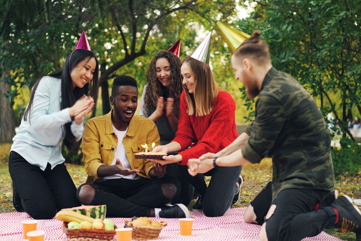 Friends having a picnic celebration outdoors, representing community access and outings support